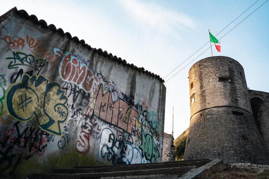 A wall of graffiti juxtaposed with a tower.