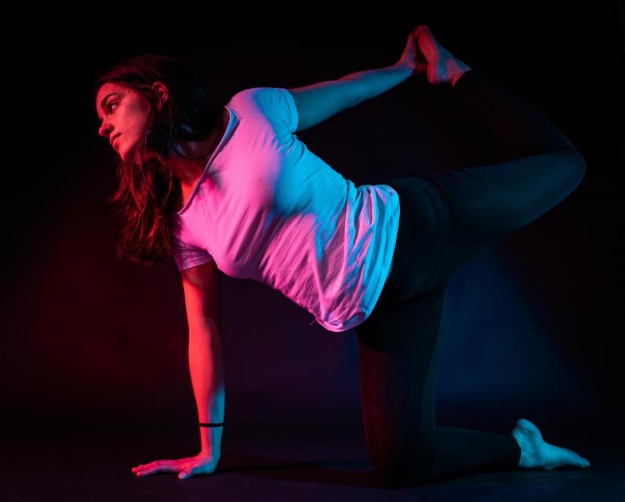 Woman yoga posing with red and blue light.